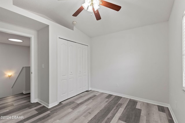 unfurnished bedroom with hardwood / wood-style flooring, ceiling fan, and a closet