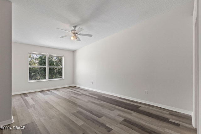 empty room with ceiling fan, a textured ceiling, and hardwood / wood-style flooring