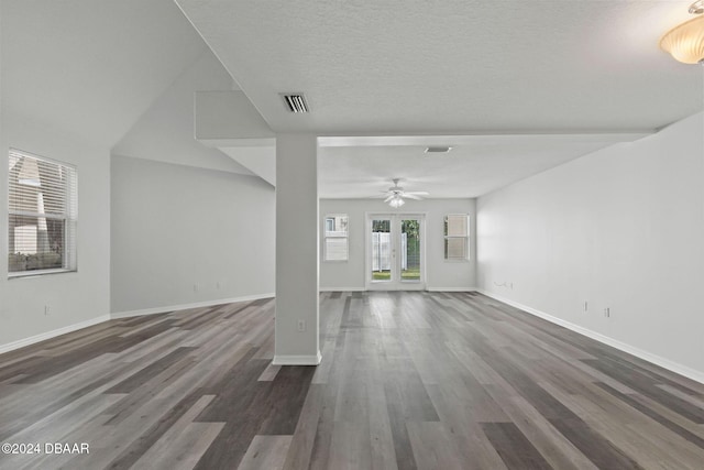 unfurnished living room with ceiling fan, dark wood-type flooring, and a textured ceiling