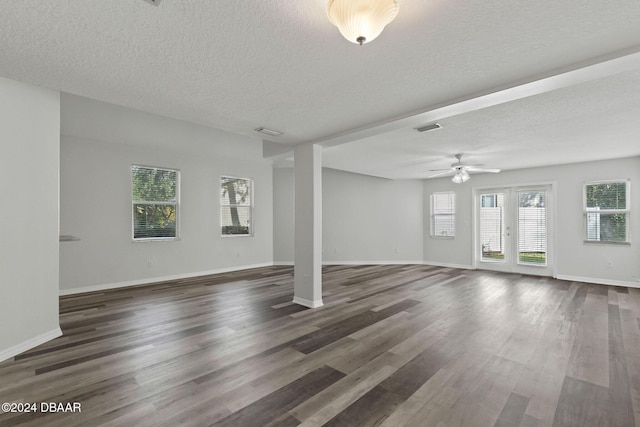 unfurnished living room with ceiling fan, dark hardwood / wood-style flooring, and a textured ceiling