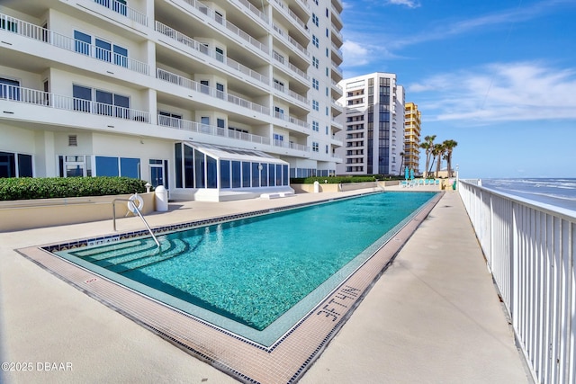 view of swimming pool featuring a patio and a water view