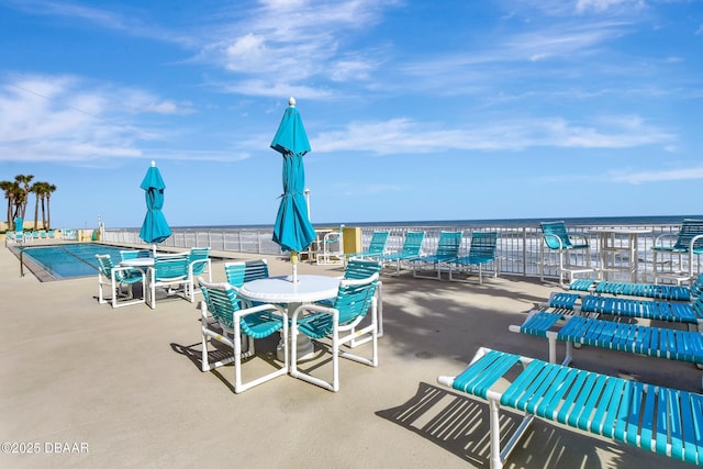 view of patio / terrace featuring a community pool and a water view