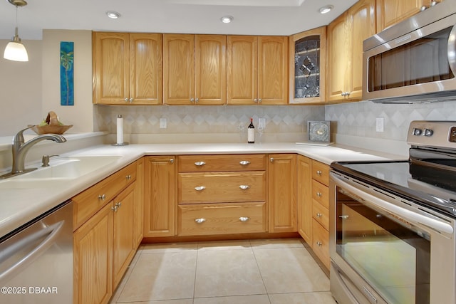 kitchen with appliances with stainless steel finishes, decorative light fixtures, sink, decorative backsplash, and light tile patterned floors