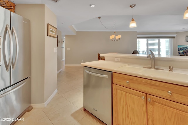 kitchen featuring pendant lighting, light tile patterned floors, sink, appliances with stainless steel finishes, and ornamental molding