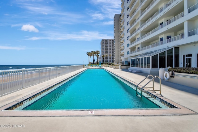 view of swimming pool featuring a patio and a water view