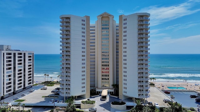 view of property with a water view and a beach view