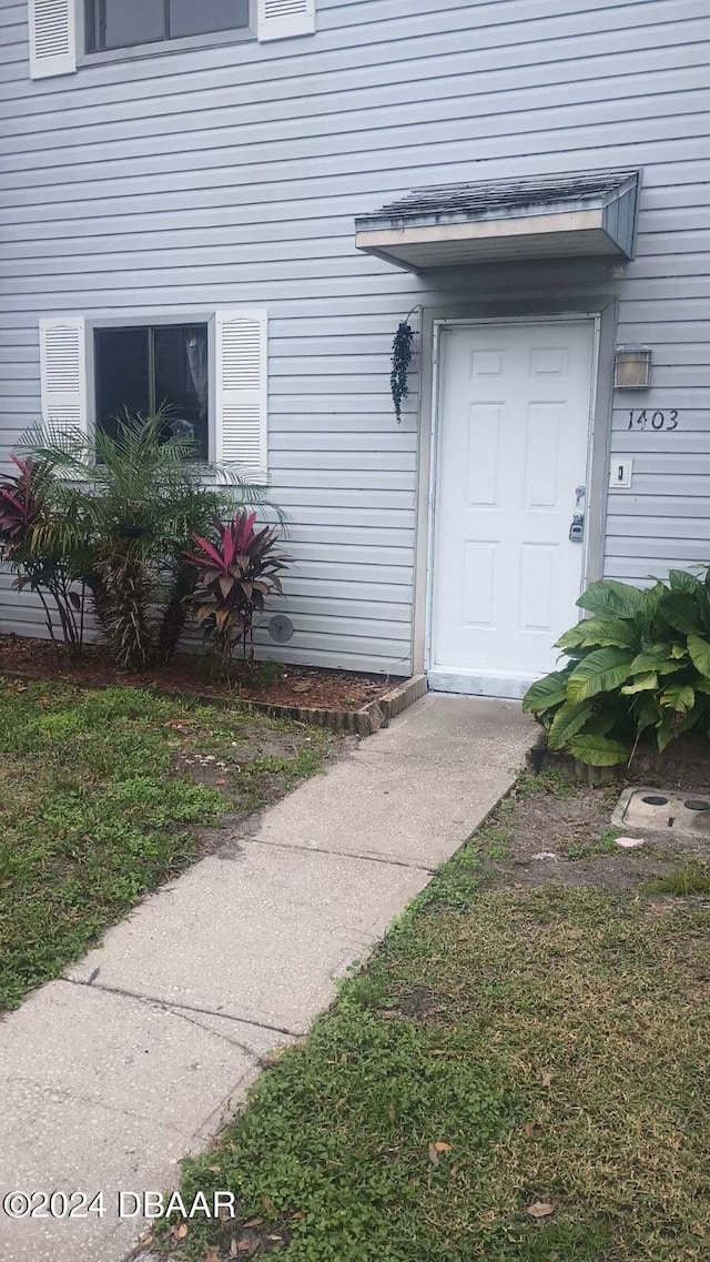 entrance to property featuring a lawn