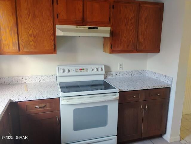 kitchen featuring white range with electric cooktop, light stone countertops, and light tile patterned floors