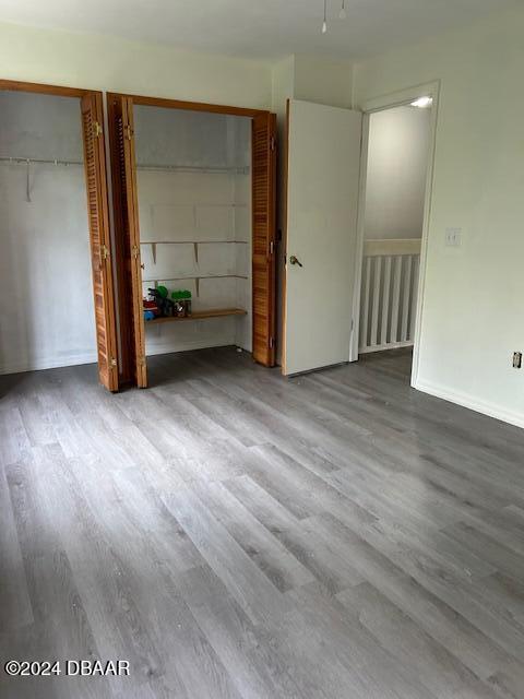 unfurnished bedroom with multiple closets and wood-type flooring