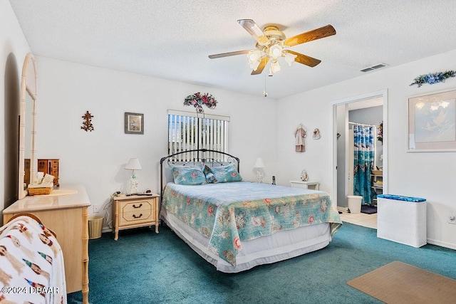 carpeted bedroom with a textured ceiling, ceiling fan, and a spacious closet