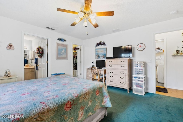 carpeted bedroom with washer / clothes dryer, ceiling fan, a closet, a walk in closet, and ensuite bath