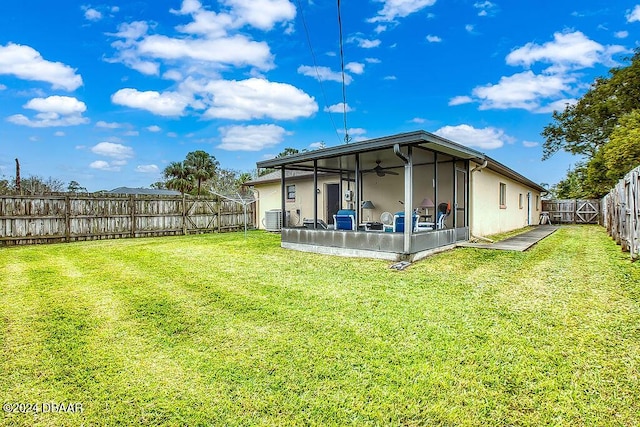 rear view of property featuring central AC unit, a yard, and a sunroom