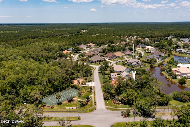 drone / aerial view with a residential view, a forest view, and a water view