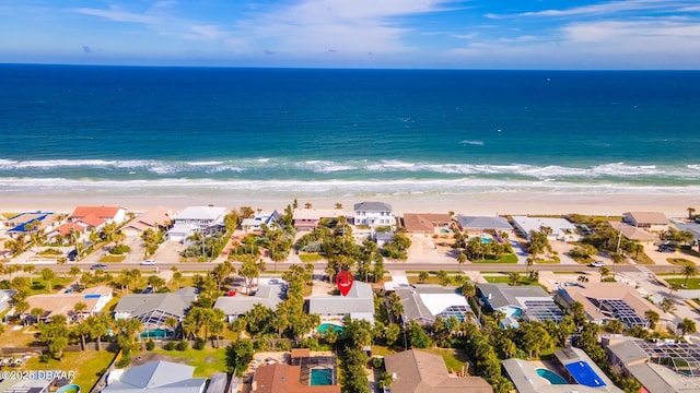 birds eye view of property with a water view and a beach view