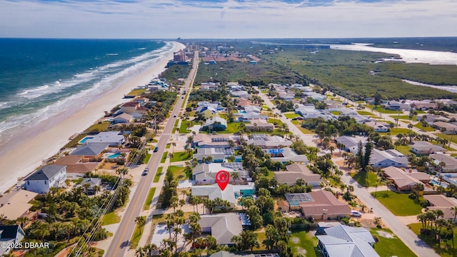 bird's eye view featuring a water view and a beach view