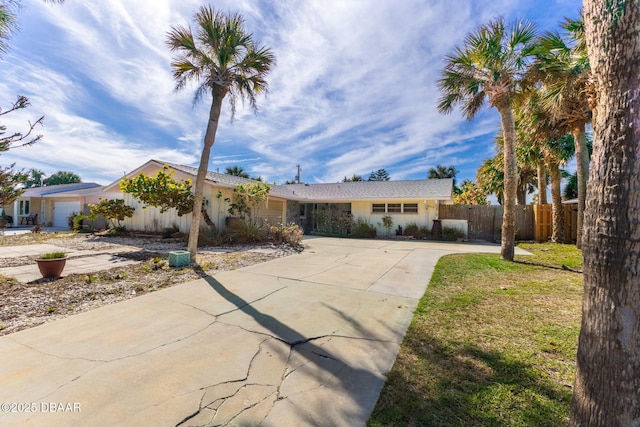 ranch-style home with a garage and a front lawn