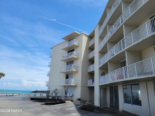 view of property featuring a water view and a beach view