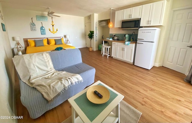 living room featuring light hardwood / wood-style floors and ceiling fan