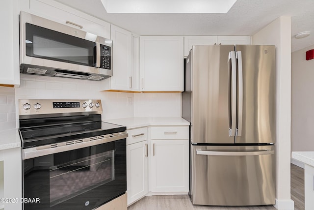 1 Oceans W Blvd Unit 7B5, Daytona Beach, FL 32118 - kitchen with light countertops, backsplash, white cabinets, and stainless steel appliances
