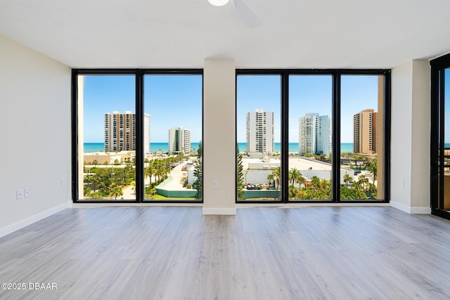 1 Oceans W Blvd Unit 7B5, Daytona Beach, FL 32118 - unfurnished room featuring a water view, wood finished floors, and a wall of windows