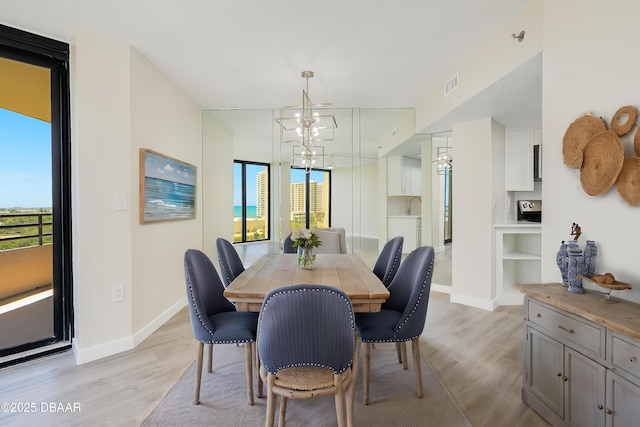 1 Oceans W Blvd Unit 7B5, Daytona Beach, FL 32118 - dining area with visible vents, built in features, light wood-type flooring, baseboards, and a notable chandelier
