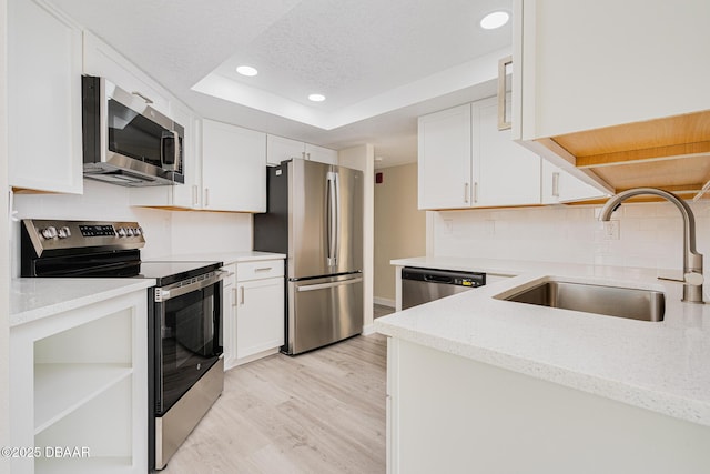 1 Oceans W Blvd Unit 7B5, Daytona Beach, FL 32118 - kitchen with white cabinets, appliances with stainless steel finishes, light wood-style flooring, and a sink