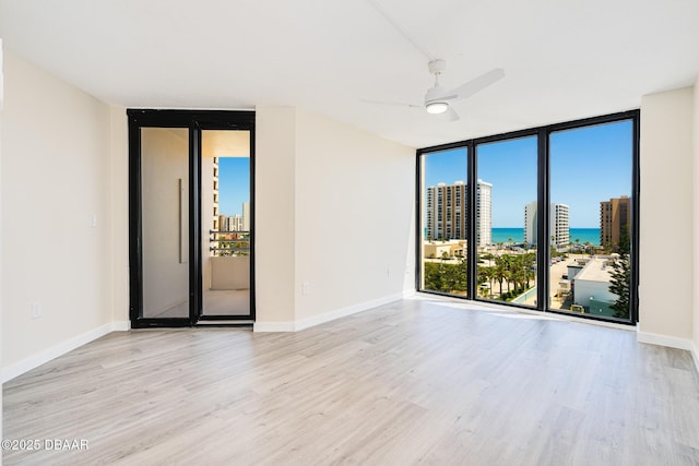 1 Oceans W Blvd Unit 7B5, Daytona Beach, FL 32118 - empty room featuring a wall of windows, a water view, wood finished floors, and ceiling fan