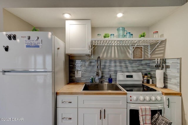 kitchen featuring white refrigerator, sink, decorative backsplash, and electric range