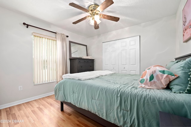 bedroom with a textured ceiling, wood-type flooring, ceiling fan, and a closet