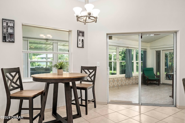 tiled dining room featuring a chandelier and a healthy amount of sunlight