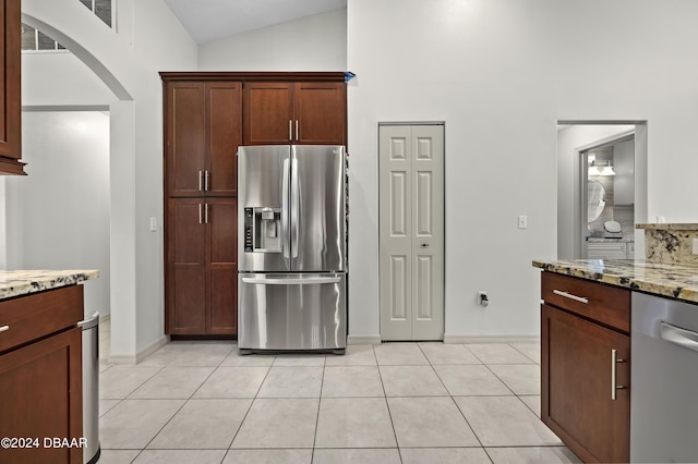 10 Pointing Pl, Palm Coast, FL 32164 - kitchen featuring stainless steel appliances, arched walkways, light tile patterned flooring, light stone countertops, and high vaulted ceiling
