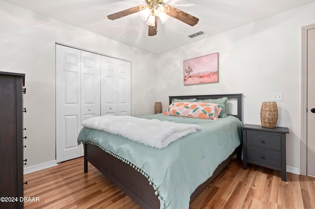 bedroom featuring ceiling fan, a closet, and light wood-type flooring