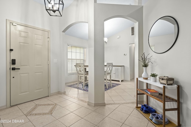 10 Pointing Pl, Palm Coast, FL 32164 - foyer featuring arched walkways, light tile patterned floors, high vaulted ceiling, and baseboards