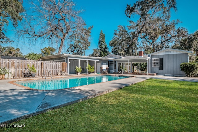 view of swimming pool with a yard