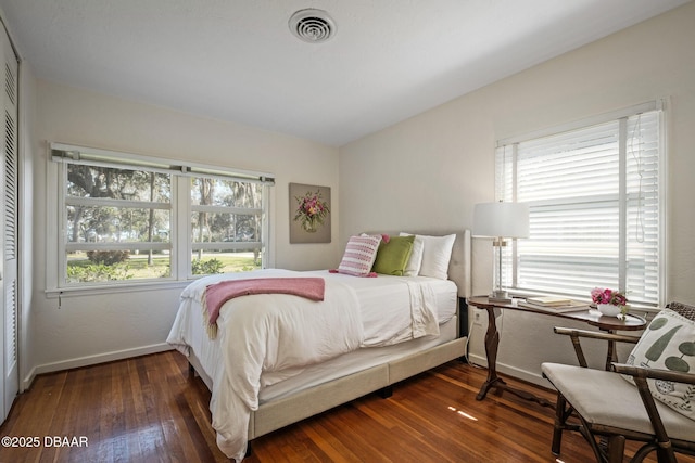 bedroom featuring dark wood-type flooring and multiple windows