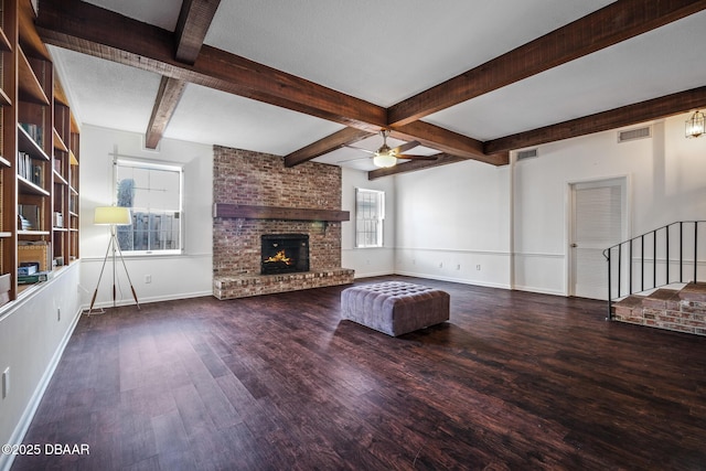 unfurnished living room featuring ceiling fan, wood-type flooring, a brick fireplace, and a wealth of natural light