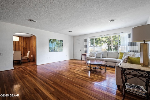 living room featuring dark wood-type flooring and a textured ceiling