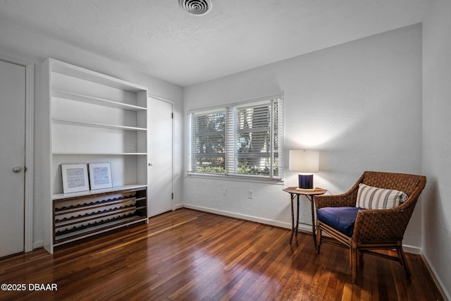 sitting room featuring dark hardwood / wood-style flooring, built in features, and a textured ceiling