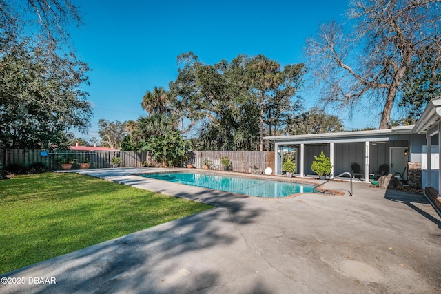 view of pool with a patio and a lawn