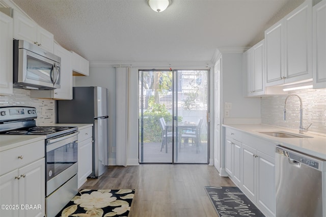 43 Jacaranda Cay Ct Unit 430, New Smyrna Beach, FL 32169 - kitchen with stainless steel appliances, light wood-type flooring, a sink, and white cabinets