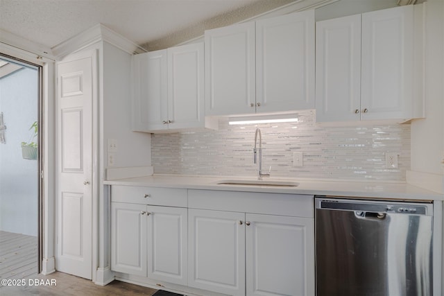 43 Jacaranda Cay Ct Unit 430, New Smyrna Beach, FL 32169 - kitchen with light countertops, backsplash, white cabinets, a sink, and dishwasher