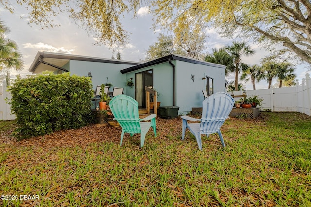 43 Jacaranda Cay Ct Unit 430, New Smyrna Beach, FL 32169 - rear view of property with a yard, fence, and stucco siding