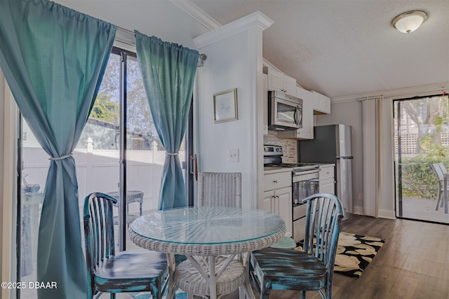 43 Jacaranda Cay Ct Unit 430, New Smyrna Beach, FL 32169 - dining area with dark wood-type flooring, plenty of natural light, and ornamental molding