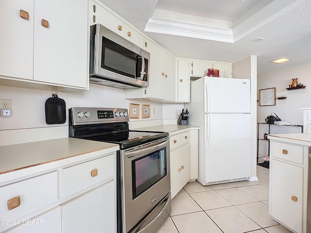 kitchen with stainless steel appliances, a textured ceiling, white cabinets, and light countertops