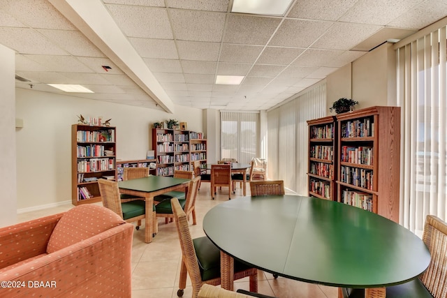 tiled dining space featuring a drop ceiling