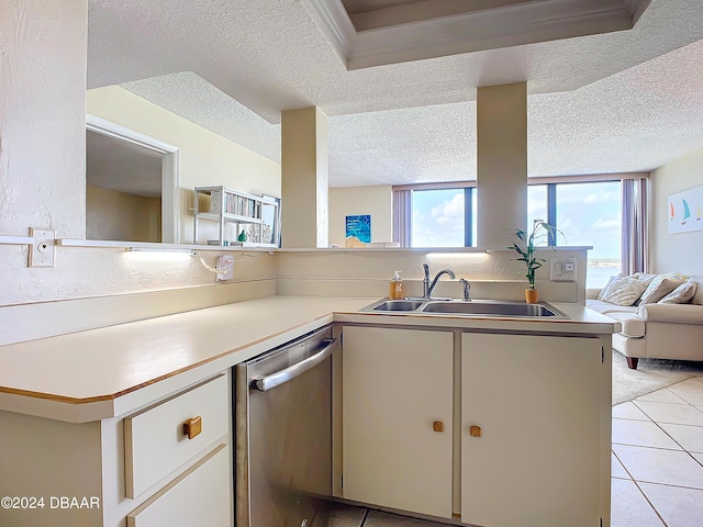 kitchen featuring open floor plan, dishwasher, light countertops, light tile patterned floors, and a sink