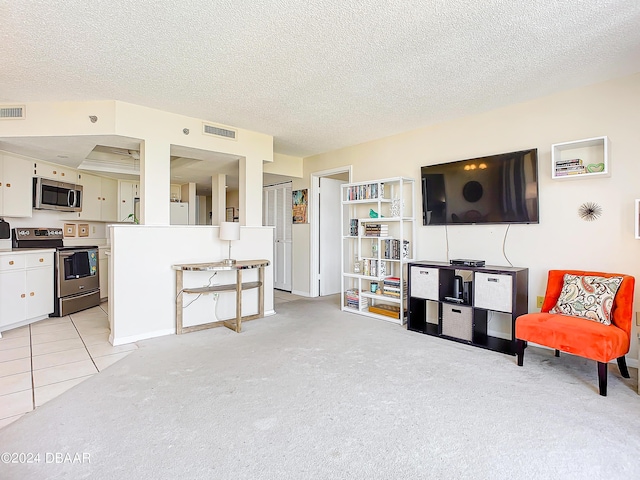 living area featuring light carpet, visible vents, and a textured ceiling