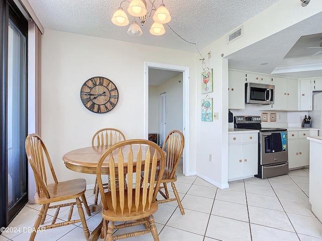 dining space featuring visible vents, baseboards, light tile patterned floors, a notable chandelier, and a textured ceiling