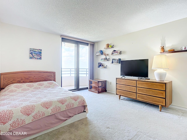 bedroom featuring a textured ceiling, carpet flooring, and access to outside