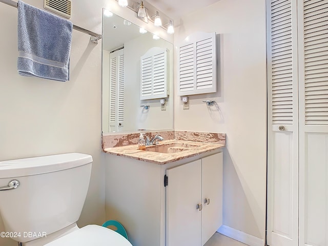 bathroom featuring a closet, visible vents, toilet, and vanity